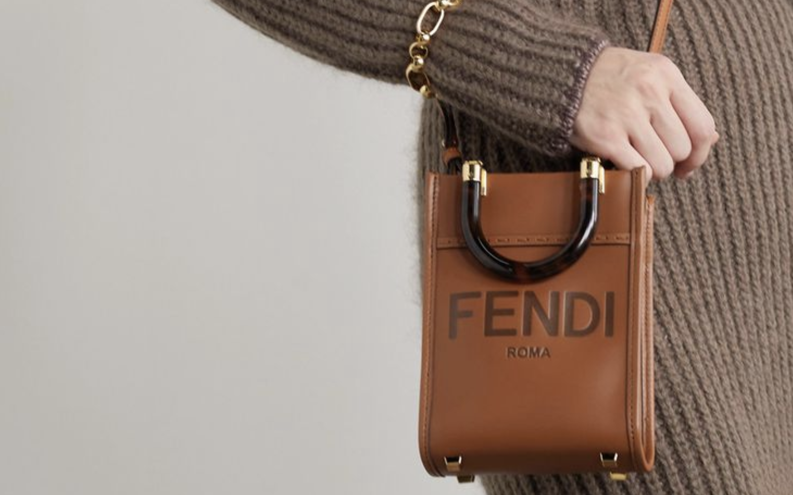 Confident woman carrying a FENDI MINI SUNSHINE SHOPPER replica in a sun-drenched European plaza. Confident woman carrying a FENDI MINI SUNSHINE SHOPPER replica in a sun-drenched European plaza.