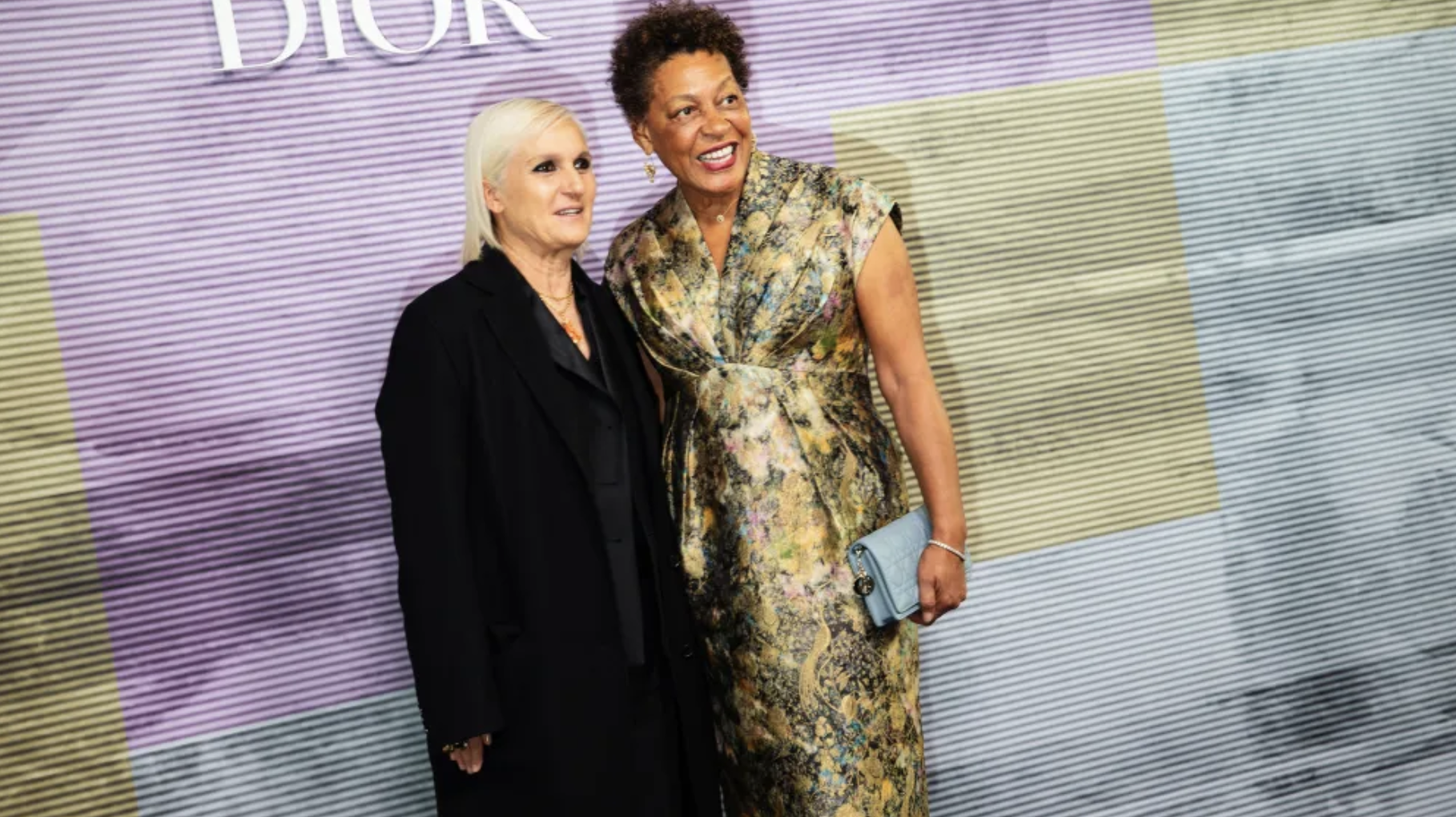 Two women posing together at a Dior event, embodying feminist values with bold outfits and confident expressions. Two women posing together at a Dior event, embodying feminist values with bold outfits and confident expressions.