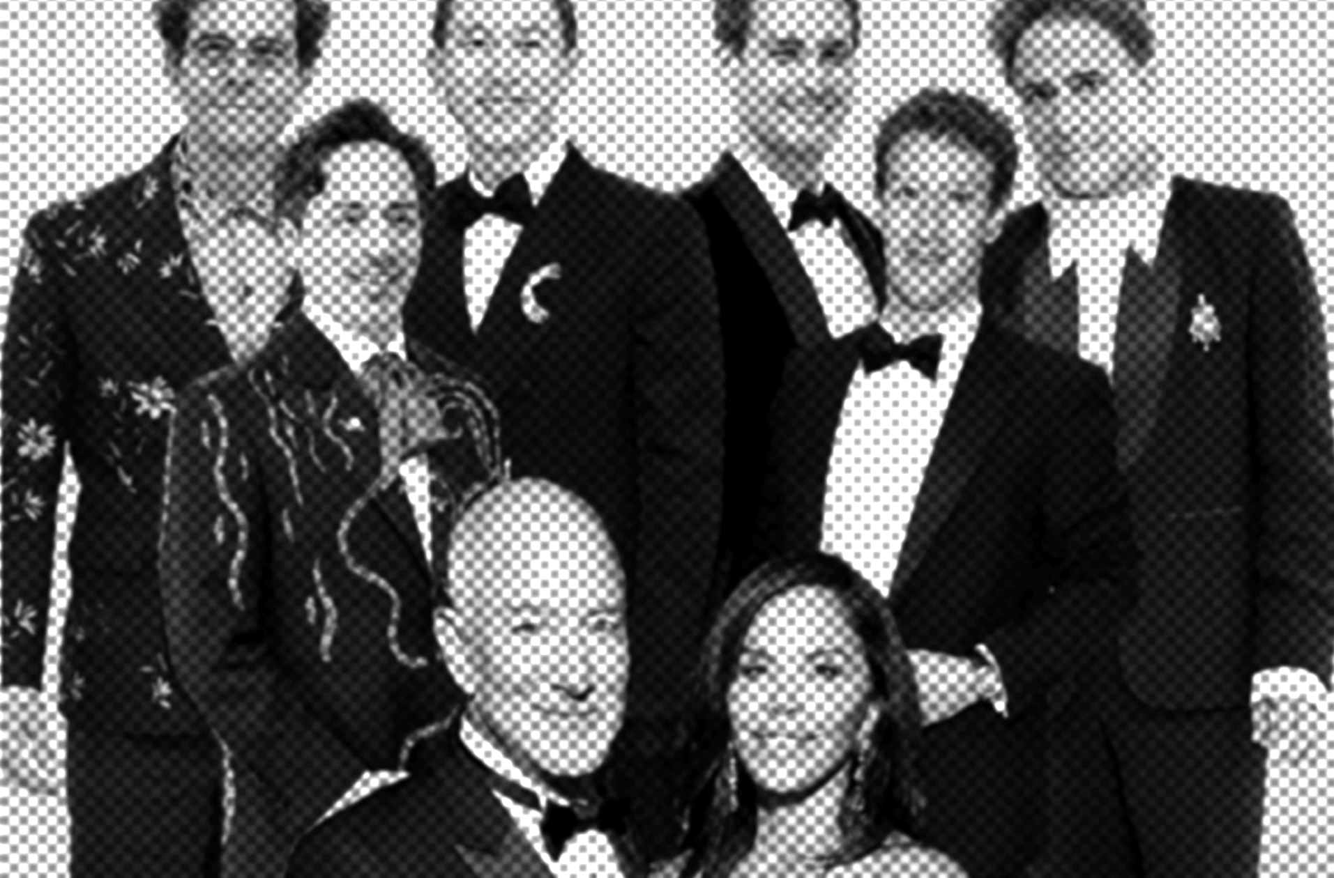 Group of people in suits and tuxedos posing for a formal group photo.